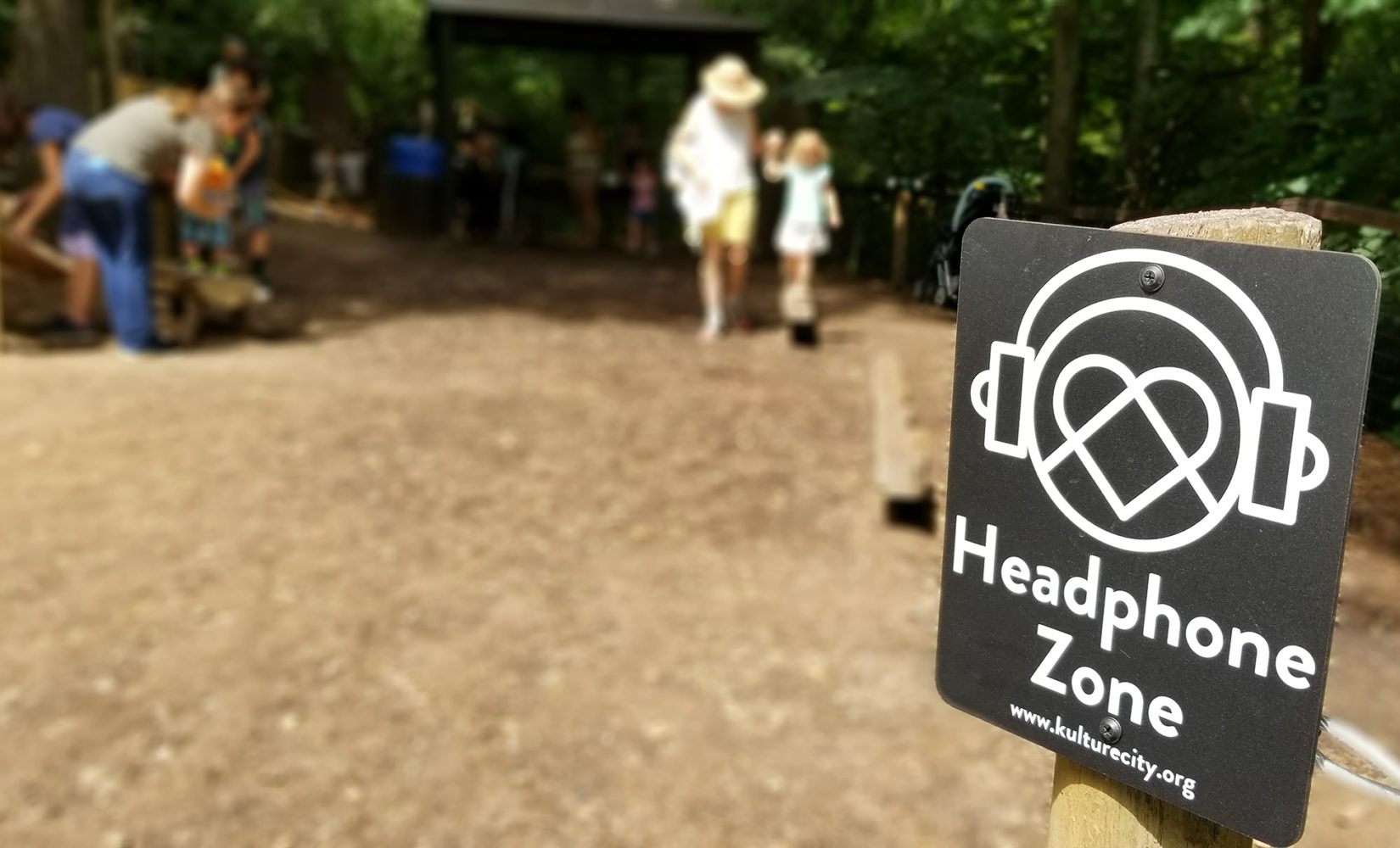 A KultureCity Headphone Zone sign at a Nature Play area.