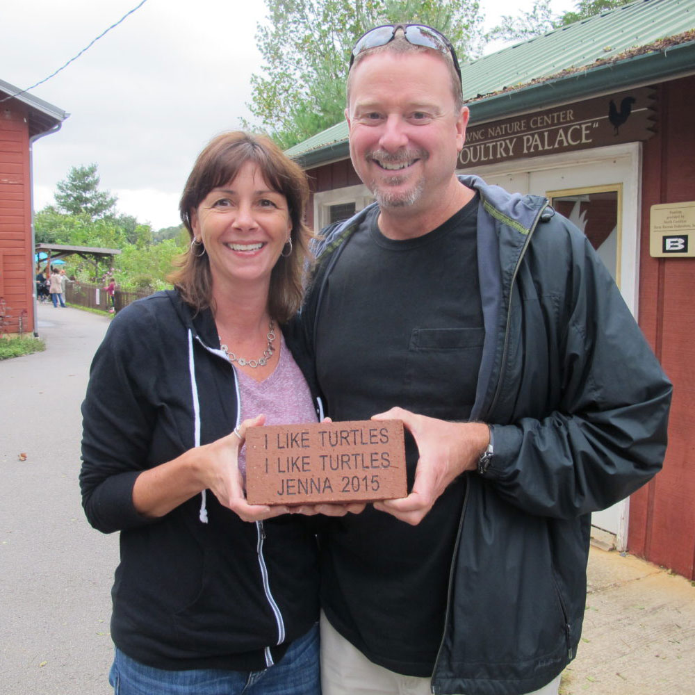 Patrons at the Nature Center showing off their donated brick with custom message.